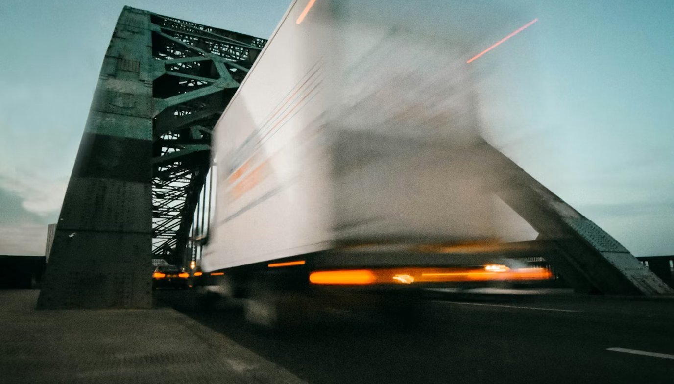 Freight truck in motion on a bridge at dusk